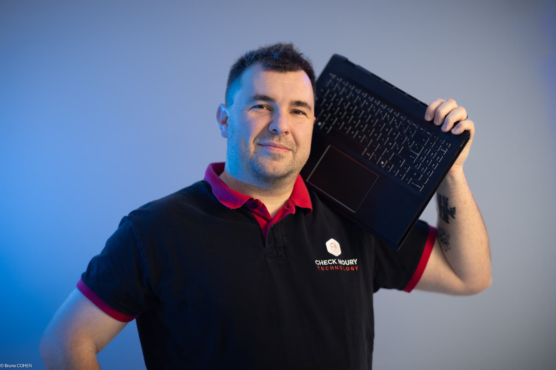 Cyril Noury, fondateur de CN-Tech, un ordinateur portable sur l'épaule